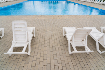 Obraz na płótnie Canvas Empty sun loungers in the resort area by the pool. Background with copy space for text