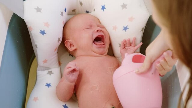 A newborn baby crying inconsolably and refused to have a bath. Unhappy kid takes military procedures for the first time. The concept of children and hygiene