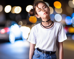Mockup, white t-shirt street template on a young beautiful girl on a background against the backdrop of an urban night city