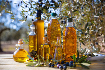 Olive oil on wooden table on background of olive tree. High quality photo