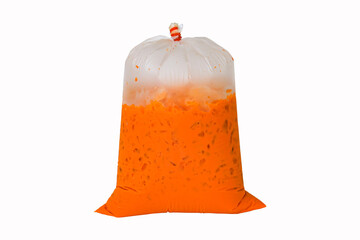 Iced milk tea color orange with crushed ice in a large plastic bag. Refreshing drink is popular in tropical countries. Isolated on white background. Packed with old fashioned bags. - obrazy, fototapety, plakaty