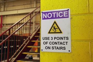 Caution sign near stairway in factory.