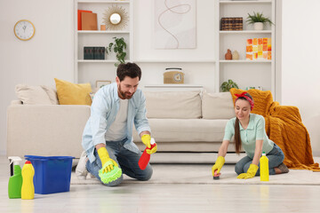 Spring cleaning. Couple tidying up living room together