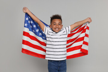 4th of July - Independence Day of USA. Happy boy with American flag on light grey background