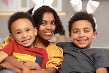 Happy African American mother and her cute children indoors