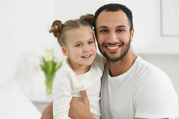 Fototapeta premium Little girl with her father spending time together at home. International family