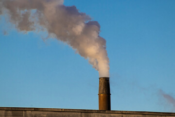 smoking chimneys of a factory plant in Brazil with blue sky background
