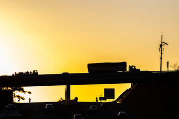 Silhouette of vehicles traveling at the intersection of the highways at gorgeous golden light sunset