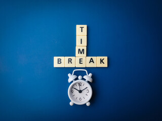 White alarm clock and toys letters with the word TIME BREAK