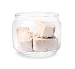 Pieces of compressed yeast in glass jar isolated on white