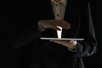 Closeup view of man using modern tablet on black background