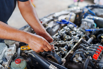 Auto mechanic repair engine in a car repair shop and Checking a car engine for repair at car garage.Car engine repair. Car service