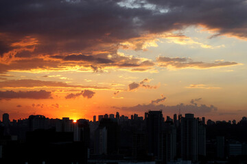 Um maravilhoso pôr do sol sobre a cidade de São Paulo, com nuvens coloridas pintando o cenário com encanto.