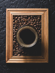 cup of coffee with roasted coffee beans, on a wooden frame, top view