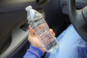 hand tightly gripping a plastic water bottle, symbolizing the environmental impact and urgency to reduce single-use plastic waste
