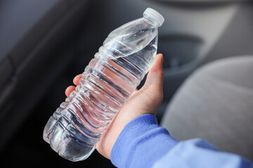 hand tightly gripping a plastic water bottle, symbolizing the environmental impact and urgency to reduce single-use plastic waste