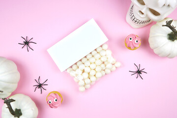 Pink Halloween treat topper party favor label mockup. Trick or treat party supplies stationery styled with white skull, pumpkins, black spiders, and spooky cupcakes. Negative copy space.