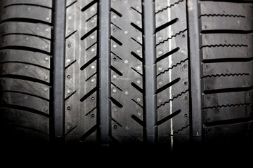 Brand new tire on a black background closeup