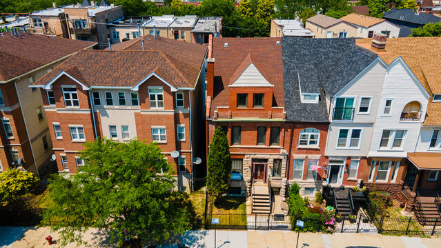 aerial drone view of a Chicago urban neighborhood during the afternoon .  the residential area is has colorful buildings great for a background. the area is quite and peaceful.
