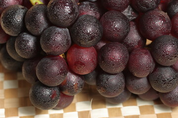 Ripe grapes for sale in the outdoor farm market. Red grapes on wooden background