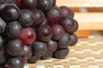 Ripe grapes for sale in the outdoor farm market. Red grapes on wooden background