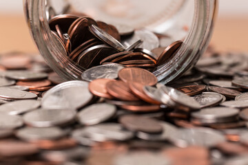 Close up of many different type of coins with jar 