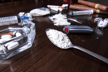 Concept of cocaine and other drugs on a table for an addict