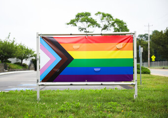 Vibrant gay pride rainbow flag intertwines with Juneteenth symbolism, celebrating freedom, equality, and diversity in a powerful fusion