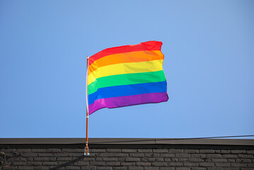 Vibrant gay pride rainbow flag intertwines with Juneteenth symbolism, celebrating freedom,...