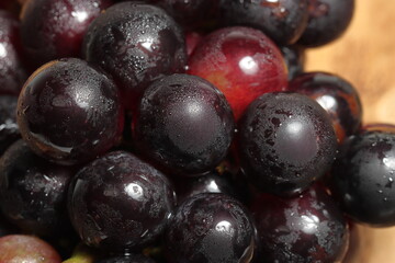 Red grapes on wooden background. Bad cholesterol prevention healthy fruits. Iron fruits