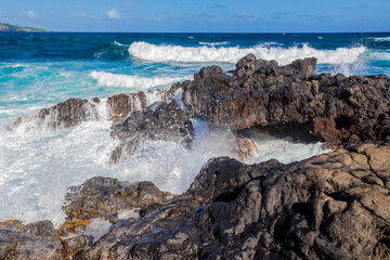 Water hitting rocks on the islands of Hawaii - obrazy, fototapety, plakaty