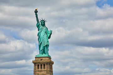 Fototapeta premium Statue of Liberty close up image against a beautiful cloudy sky on a summer day