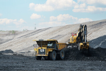 Large mine dump truck and excavator. heavy equipment loading coal in quarry