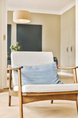 a living room with a white couch and blue throw pillow on the sofa is in front of a black wall