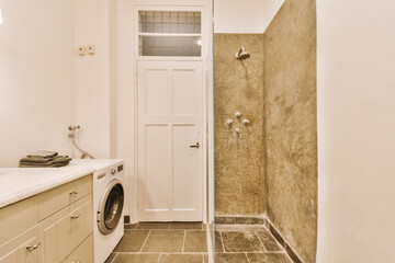 a laundry room with a washer and dryer on the floor in front of the door to the bathroom
