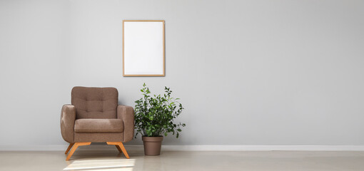 Cozy armchair and houseplant near light wall. Banner for design