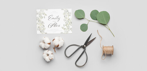 Composition with beautiful wedding invitation, scissors and cotton flowers on light background