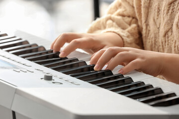 Fototapeta premium Woman playing modern synthesizer, closeup