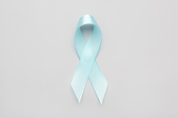 Blue satin ribbon on light background. Prostate cancer concept