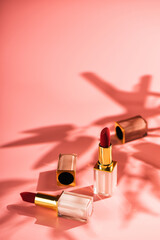 Red lipstick beauty product on a pink background