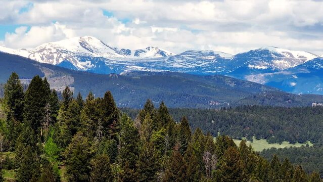 Colorado cinematic aerial drone Rocky Mountains layers Denver continental divide Mount Evans 14ers parallax zoom forest snow on peaks spring summer cloudy thunderstorm lush green Evergreen Aspen left