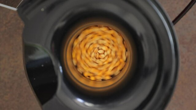 Pop corn kernel spinning in electric machine, top close up shot