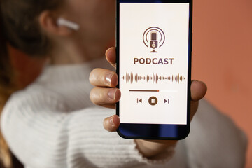 Unrecognizable woman holding mobile phone Podcast listening website page app application with wireless headphones. Audio healing, sound therapy wellness rituals, positive mental health habits