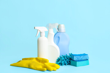 Different cleaning supplies on blue background