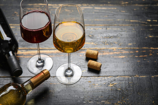 Glasses of exquisite wine on dark wooden background