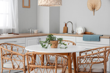 Interior of light kitchen with dining table and white counters