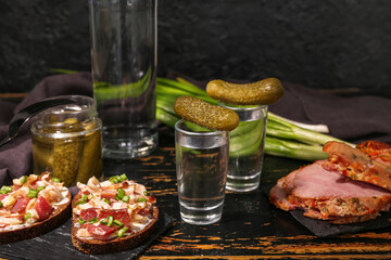 Shots with cold vodka and snacks on table