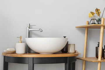 Sink bowl and bath accessories on table in bathroom, closeup