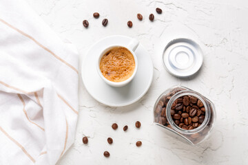Obraz na płótnie Canvas Cup of hot espresso and jar with coffee beans on white background