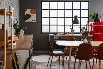 Interior of modern kitchen with dining table and grey counters